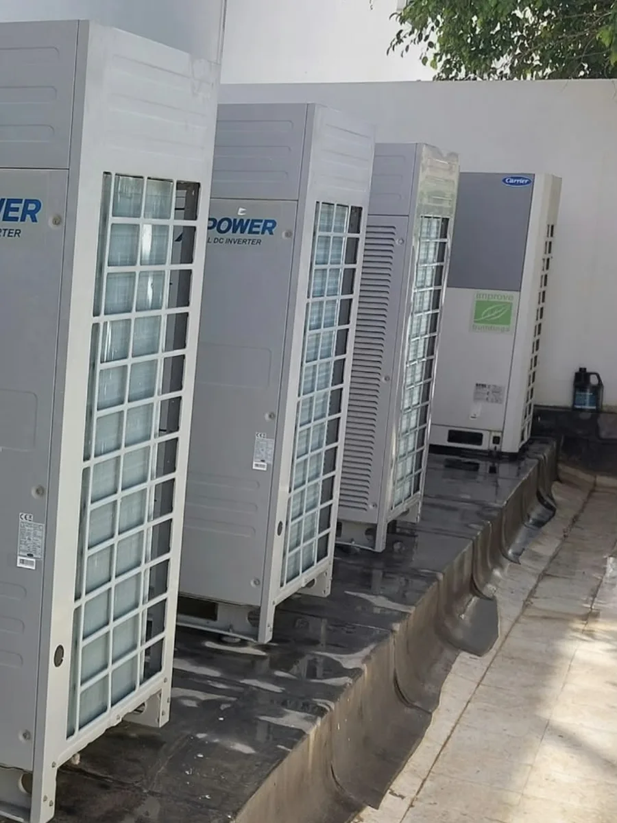 Rangée de groupes extérieurs de climatisation nettoyés le long d'un mur