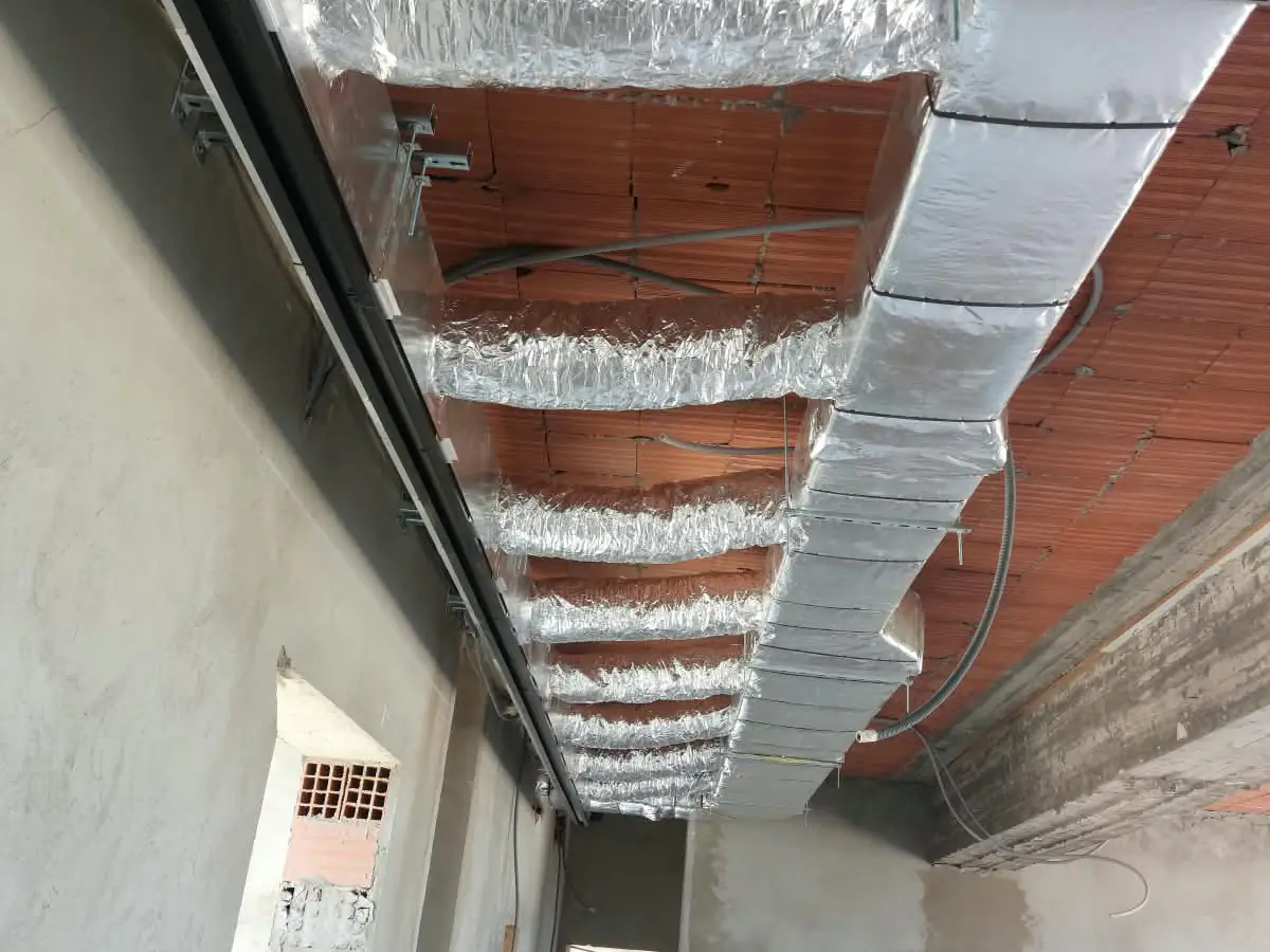 Réseau de gaines de climatisation le long du couloir d'une villa en construction