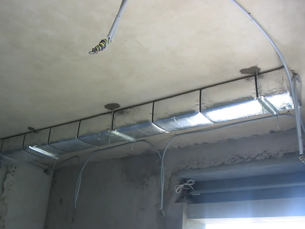 Gaine et grilles de soufflage le long du plafond d'un plateau de bureaux